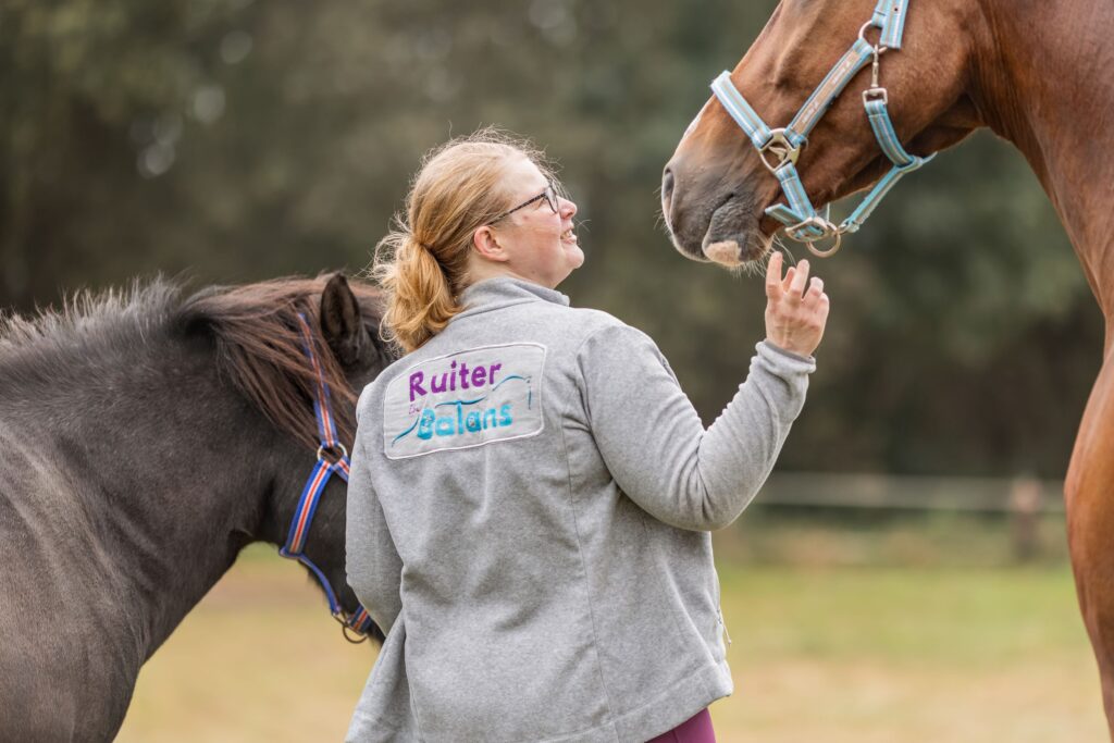 Marloes van achteren gezien en haar twee paarden
